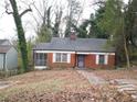 Classic red brick home with a screened porch and a quaint front yard surrounded by lush greenery at 1191 Beechview Se Dr, Atlanta, GA 30316