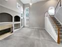 Bright living room featuring a fireplace, large window, and staircase at 2708 Stockbridge Way, Dacula, GA 30019