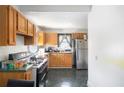 A compact kitchen design with wood cabinets, stainless steel refrigerator, and black and silver appliances at 207 Taylor Cir, Palmetto, GA 30268