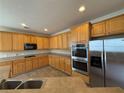 Spacious kitchen featuring wooden cabinets, stainless steel appliances, a breakfast bar, and tile flooring at 4310 Alysheba Dr, Fairburn, GA 30213