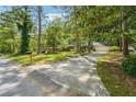 Long concrete driveway leading up to a single-story home surrounded by mature trees at 6565 Katie Ln, Morrow, GA 30260