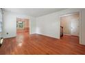 Open-concept living room featuring hardwood floors, neutral walls, and access to other rooms at 6565 Katie Ln, Morrow, GA 30260