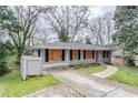 Single-story home with gray brick, dark shutters, and side yard with fence at 1826 Meadowglades Dr, Decatur, GA 30035