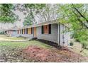 Gray brick single-story home with dark shutters, and lawn on a cloudy day at 1826 Meadowglades Dr, Decatur, GA 30035