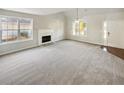 Bright living room with fireplace, large windows providing ample natural light, and neutral-colored carpet at 122 Sanders Walk, Mcdonough, GA 30252