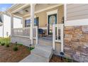 Inviting front porch with stone accents, offering a cozy outdoor seating area at 1353 Wilson Manor Cir, Lawrenceville, GA 30045