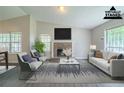 Bright, staged living room featuring vaulted ceilings, a brick fireplace and large windows for natural light at 5500 Marbut Forest Way, Lithonia, GA 30058