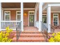 Inviting brick front porch with white columns, and a cozy seating area at 677 Brennan Dr, Decatur, GA 30033