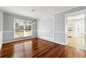 Dining room with rich hardwood floors, decorative molding, and modern pendant lighting at 3744 Misty Wood Nw Dr, Marietta, GA 30064