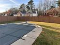 Backyard pool featuring a safety cover and a perimeter of well-maintained lawn at 921 Peel Castle Ln, Austell, GA 30106