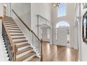 Welcoming foyer with a high ceiling, wooden staircase, and large front door with transom window at 1900 Sanborne Way, Dacula, GA 30019