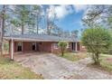 Back exterior view of the property with driveway and ample parking, covered carport, and a brick facade at 2458 Kelly Lake Dr, Decatur, GA 30032