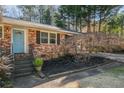 Close up of blue front door, brick facade and walkway with lush landscaping at 2781 Hollywood Dr, Decatur, GA 30033