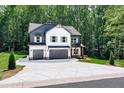 Two-story home featuring a two-car garage, a mix of board and batten and lap siding, and professional landscaping at 2905 Ivy Mill Drive Dr, Buford, GA 30519