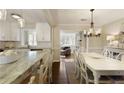 Light-filled dining room with white table and chairs and views of kitchen and the living room at 168 Maribeau Nw Sq, Atlanta, GA 30327