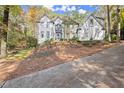 Elegant home exterior with a manicured front yard and a long driveway, offering curb appeal at 2680 Spalding Dr, Sandy Springs, GA 30350