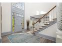 Bright foyer with a high ceiling, gray trim, wood floors, and a staircase at 2680 Spalding Dr, Sandy Springs, GA 30350