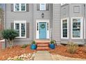 Inviting front entrance with a blue door, decorative wreath, and charming landscaping at 708 Players Ct, Woodstock, GA 30189