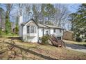 Side view of the two-story house showcasing the green lawn and stairs to the front door at 5570 Deerfield Nw Pl, Kennesaw, GA 30144