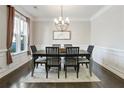 Elegant dining room featuring wainscoting, modern chandelier, and large window at 167 Marlow Dr, Woodstock, GA 30188