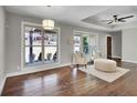 Sun-filled living room featuring hardwood floors, neutral paint, statement lighting, and two large windows at 1988 Boulderview Se Dr, Atlanta, GA 30316