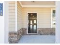 Inviting home entrance featuring a covered porch with brick accents at 7783 Hansel Ln, Lithonia, GA 30058