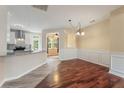Open dining room with hardwood floors adjacent to a modern kitchen and bright breakfast nook at 240 Village Square Dr, Woodstock, GA 30188