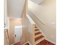 Bright hallway featuring hardwood stairs, newel posts, and a crisp white front door at 240 Village Square Dr, Woodstock, GA 30188