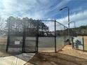 Well-maintained tennis court surrounded by a secure fence and beautiful trees at 240 Village Square Dr, Woodstock, GA 30188