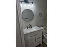 Updated bathroom features a white vanity, round mirror, updated light fixture and black hardware at 3201 Fairington Dr, Lithonia, GA 30038