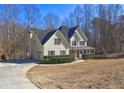 Side view of a yellow home with a covered porch, attached garage, and lush green landscaping at 596 Whitby Dr, Douglasville, GA 30134