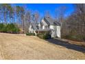 Spacious yellow two-story home with a covered porch, surrounded by trees and a large front yard at 596 Whitby Dr, Douglasville, GA 30134