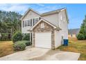 Charming home exterior with stone accents, a gray siding, and a one car garage at 4872 Antelope Cv, Atlanta, GA 30349