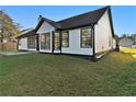 Exterior view of home with large windows overlooking a grassy backyard at 690 Avalon Forest Dr, Lawrenceville, GA 30044