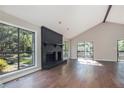 Bright living room with large windows, hardwood floors, and a striking black brick fireplace at 2830 Jodeco Dr, Jonesboro, GA 30236