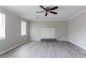 Bright living room with a ceiling fan, grey laminate flooring, and a decorative fireplace at 2172 Red Rose Ln, Loganville, GA 30052