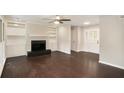 Spacious living room featuring hardwood floors, a fireplace with built-in shelving, and decorative glass pane front doors at 4902 Cedar Se Ct, Conyers, GA 30094