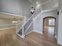 Spacious foyer with a beautiful staircase, hardwood floors, and elegant lighting fixtures at 7910 Tintern Trce, Duluth, GA 30097