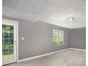 Spacious room featuring light gray walls, light flooring, and a door leading to the backyard at 8740 Parliament Pl, Jonesboro, GA 30238