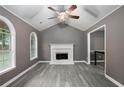 Cozy living room with vaulted ceilings, a white brick fireplace, and neutral gray paint with gray floors at 8740 Parliament Pl, Jonesboro, GA 30238