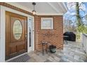 Inviting front porch with brick accent, decorative door, and tiled flooring at 8540 Hope Mews Ct, Atlanta, GA 30350