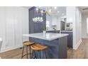Kitchen island with white countertop, gray cabinets, and seating for two in modern kitchen at 75 Mayson Ne Ave, Atlanta, GA 30307