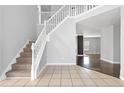 Inviting foyer with staircase, neutral tile flooring, and views into the home's living spaces at 1116 Oak Hollow Ln, Hampton, GA 30228