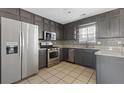 Well-lit kitchen featuring stainless steel appliances, granite countertops, tile backsplash, and gray cabinetry at 1116 Oak Hollow Ln, Hampton, GA 30228