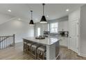 Bright kitchen featuring a large island with seating, sleek cabinets and modern pendant lights at 1238 Ainsworth Aly # 38, Sugar Hill, GA 30518