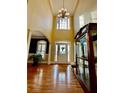 Grand two-story foyer with hardwood floors, chandelier, and open archway creating an inviting entrance at 3585 Shepherds Ln, Loganville, GA 30052