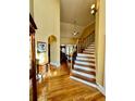 Elegant foyer with gleaming hardwood floors and a staircase with white risers and dark wood railing at 3585 Shepherds Ln, Loganville, GA 30052