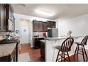 Well-appointed kitchen featuring dark cabinets, granite countertops, and a convenient breakfast bar at 209 Townview Dr, Woodstock, GA 30189