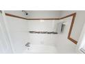 Bathroom with a built-in bathtub featuring white tiling and a brown decorative border at 2653 Williamsburg Dr, Decatur, GA 30034