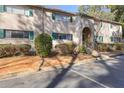 Attractive condo building featuring a brick facade, lush landscaping, and charming green shutters at 3236 Henderson Mill Rd, Atlanta, GA 30341